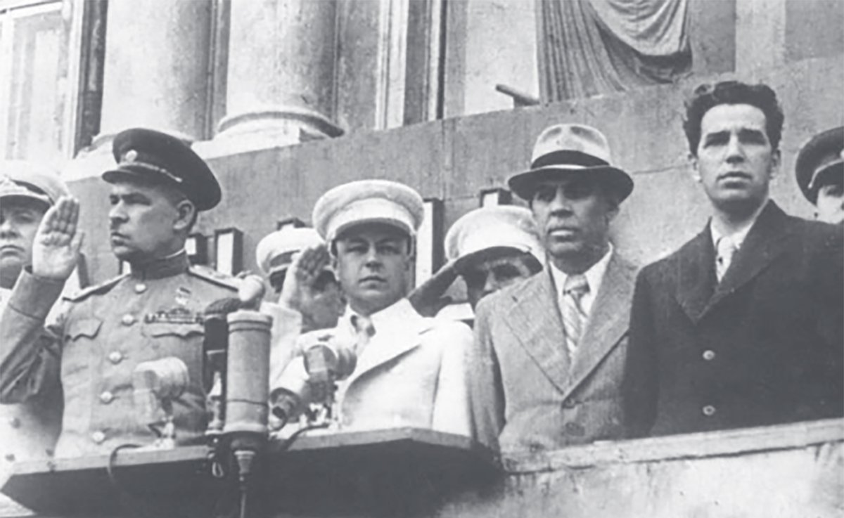 Председатель исполкома Ленинградского городского Совета депутатов трудящихся П. С. Попков (второй справа) и первый секретарь Ленинградского обкома и горкома ВКП(б) А. А. Кузнецов (первый справа) на трибуне на Дворцовой площади, Ленинград, 1945 год. Фото:  mirpeterburga.ru