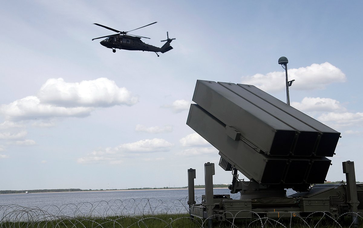 Вертолет Black Hawk армии США и испанский зенитно-ракетный комплекс (NASAMS) на учениях «Латвийский щит 25» на Рижской гидроэлектростанции в Доле, Латвия, 28 мая 2025 года. Фото: Toms Kalnins / EPA