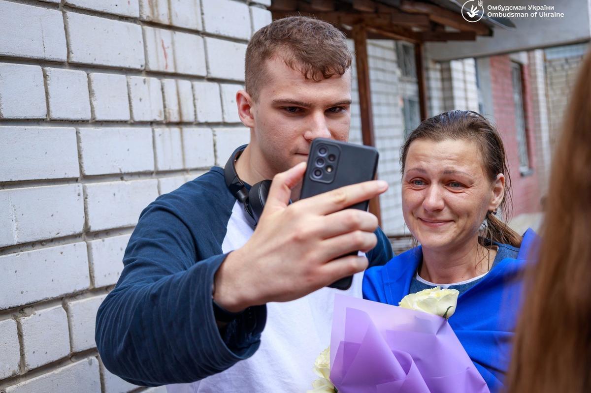 Саша Кириченко встретил из плена свою крестную, Светлану Головань, и они вместе звонят родным в Новоазовск. Фото: Офис Омбудсмена Украины