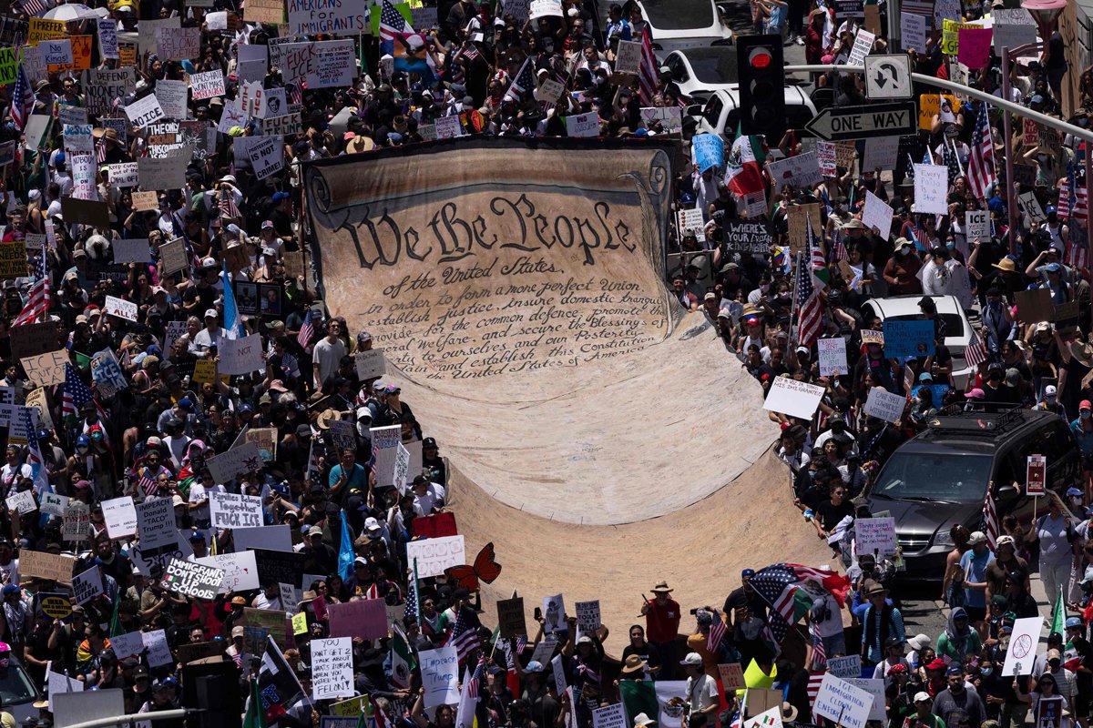 Участники акции «Никаких королей» разворачивают баннер с надписью We the People («Мы, народ») — первыми словами преамбулы Конституции США — во время митинга в Лос-Анджелесе, Калифорния, 14 июня 2025 года. Фото: Etienne Laurent / AFP / Scanpix / LETA