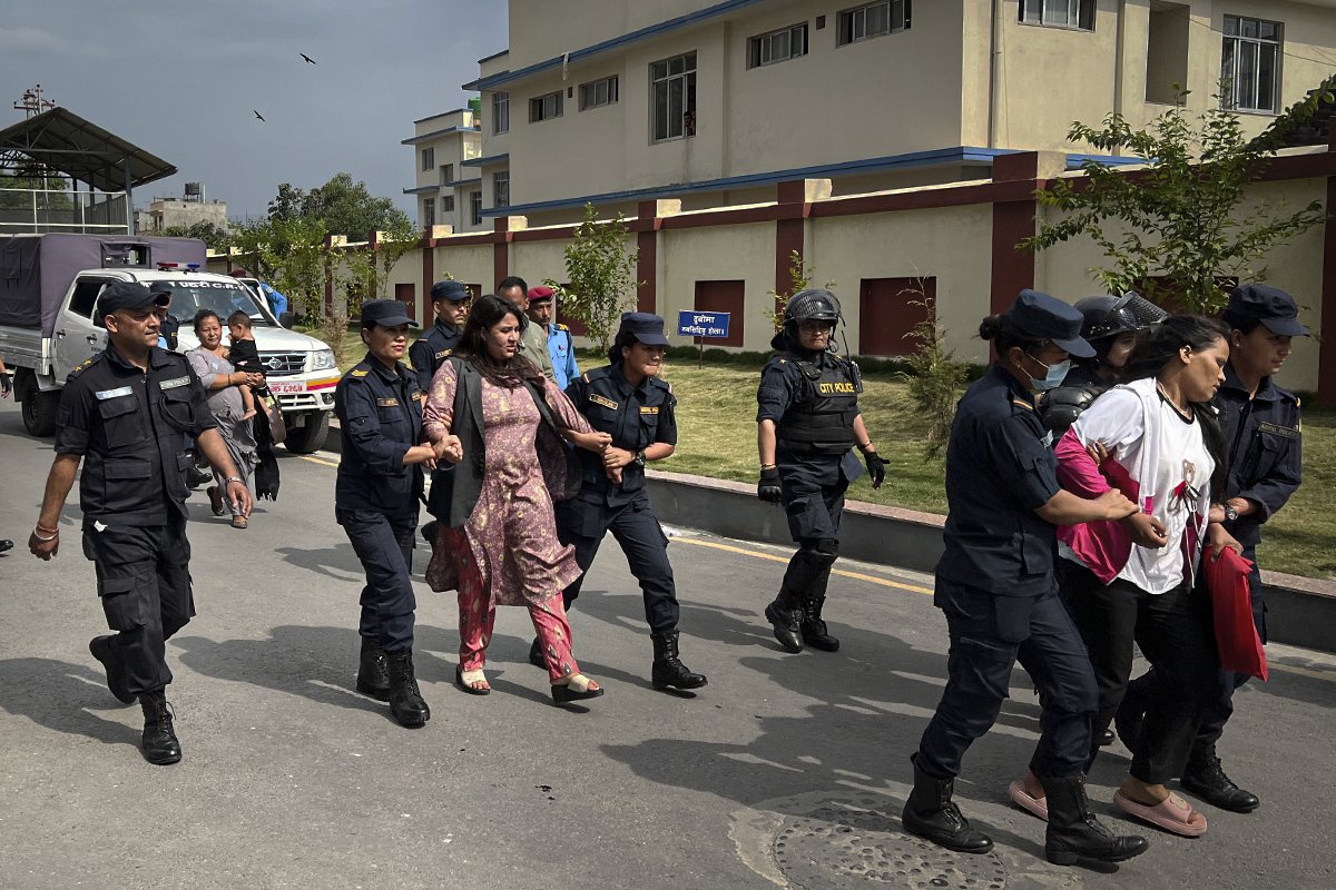 Полицейские выводят с территории МИДа Дипу Сингх Шахи (на переднем плане) и Криту Бхандари (на заднем). Фото: Ирина Кравцова / «Новая газета Европа»