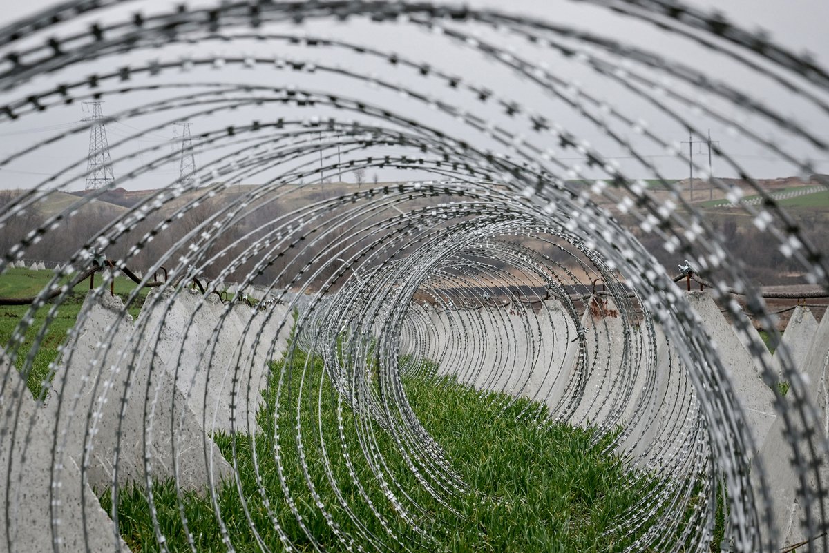 Проволочные заграждения и противотанковые ежи на поле с ячменём в Запорожской области, 17 марта 2025 года. Фото: Dmytro Smolienko / Ukrinform / ZUMA Press Wire /  SplashNews.com  / Vida Press