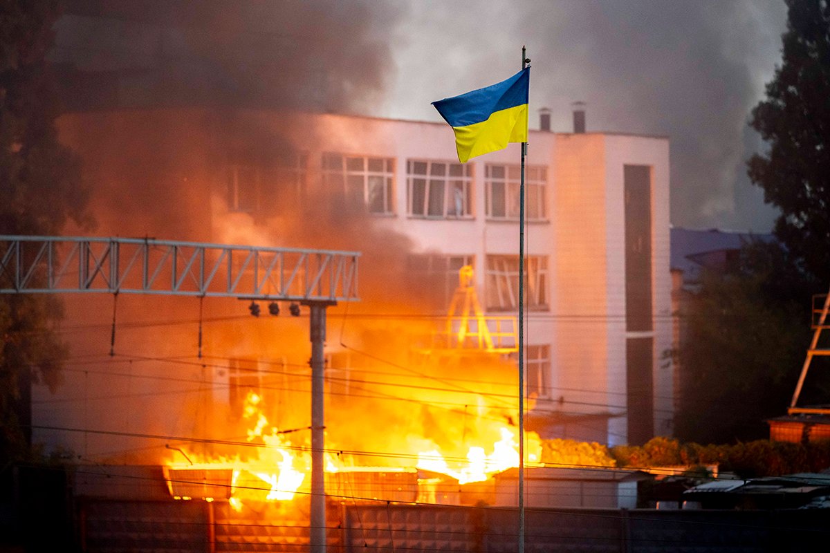 Украинский флаг на фоне огня в Киеве после российских ракетных обстрелов Украины, 2 сентября 2024 года. Фото: Andreas Stroh / IMAGO / Scanpix / LETA