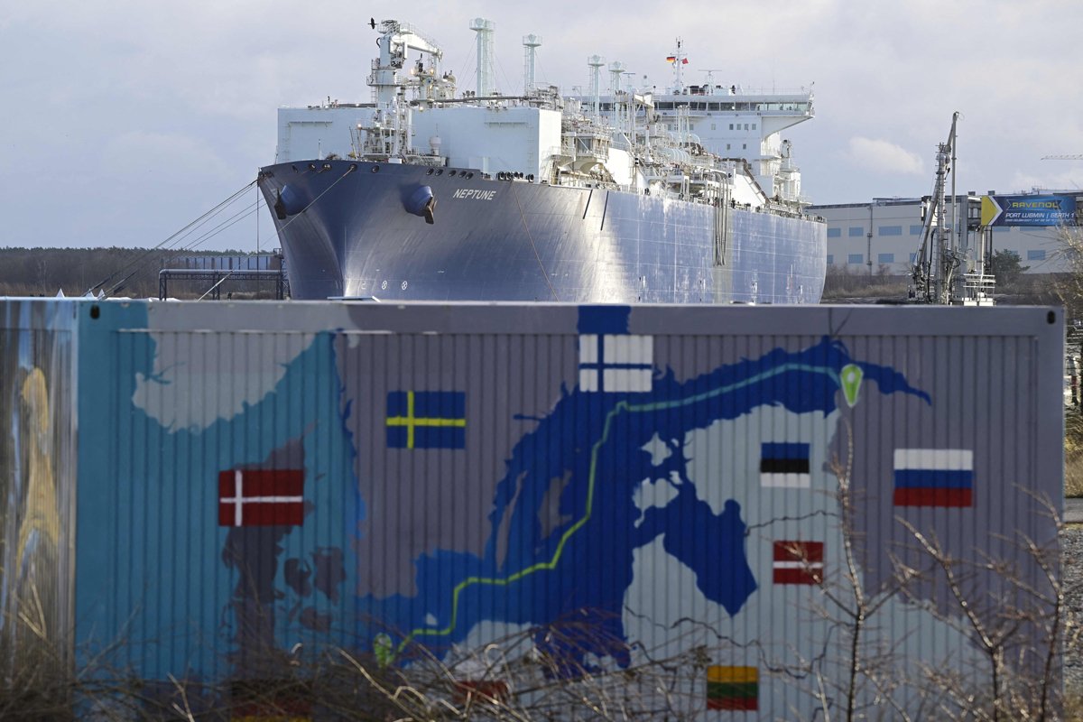 Плавучая установка для приёма и преобразования сжиженного газа Neptune на фоне контейнера с картой газопровода «Северный поток — 2», Любмин, Германия, 14 января 2023 года. Фото: John MacDougall / AFP / Scanpix / LETA