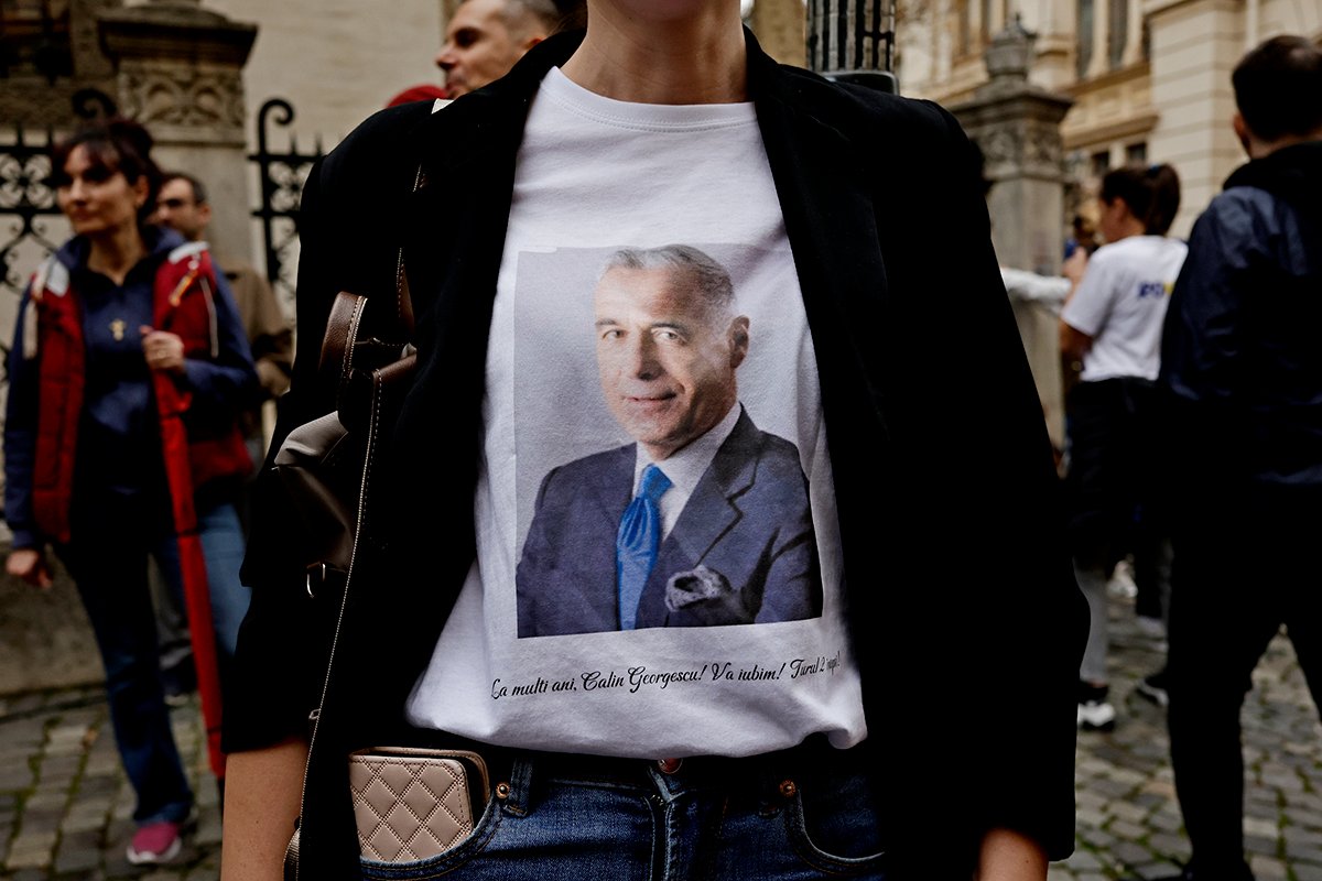 Женщина в футболке с портретом Кэлина Джорджеску во время акции протеста, организованной партией «Альянс за союз румын» (AUR) против отмены первого тура президентских выборов, в центре Бухареста, Румыния, 1 марта 2025 года. Фото: Robert Ghement / EPA-EFE